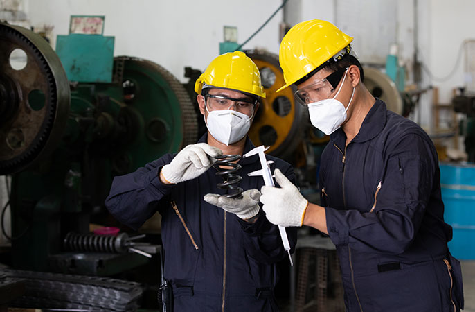 Technicians are measuring spring with caliper